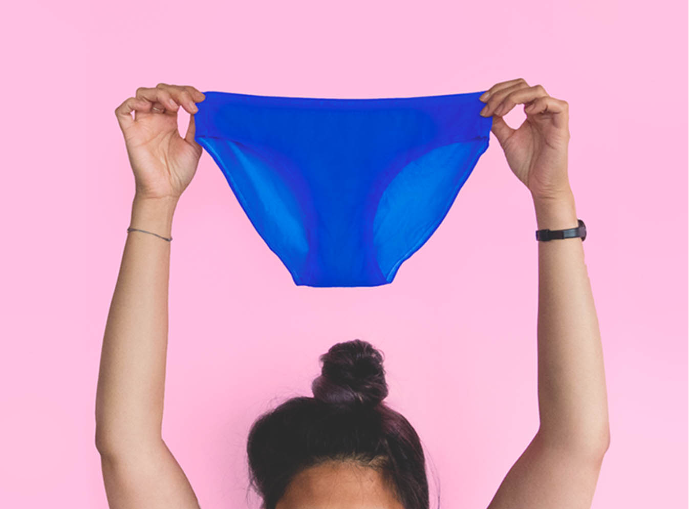 Bras de femme tenant une culotte bleue